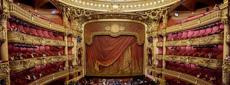 Interior del auditorio de la Ópera Garnier con sus cinco niveles de palcos en terciopelo rojo y la gran lámpara de araña